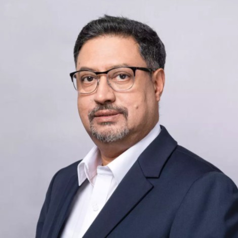 Alok Sinha wearing a navy suit and glasses